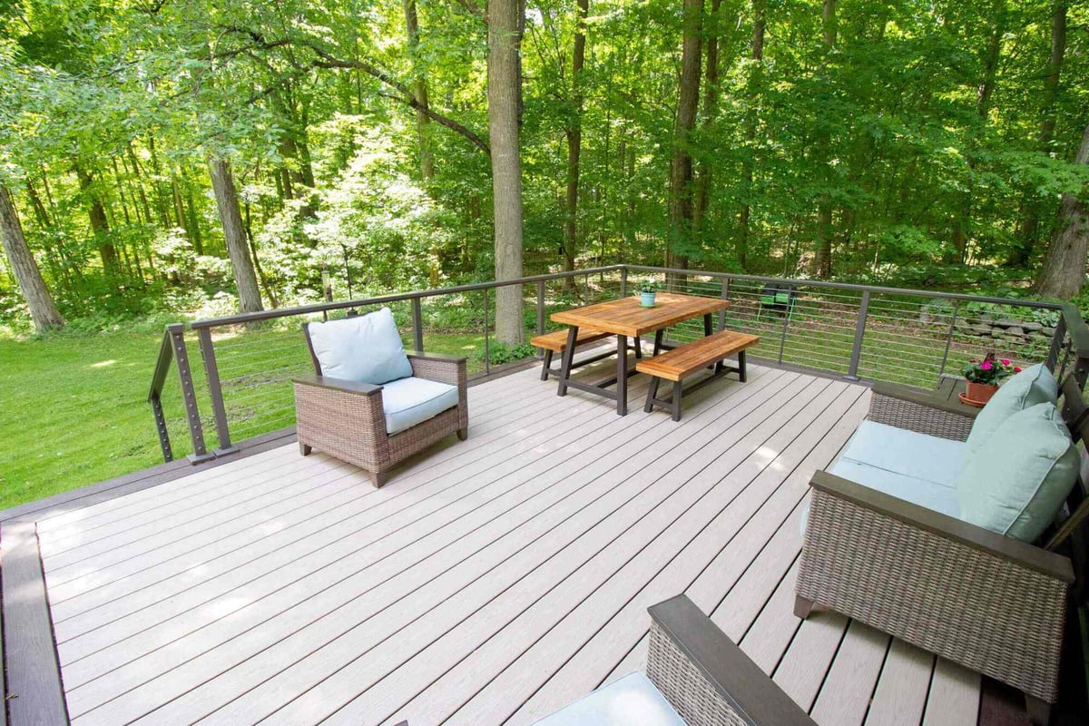 Elevated composite deck with outdoor furniture by Odd Fellows Contracting in Mason, MI