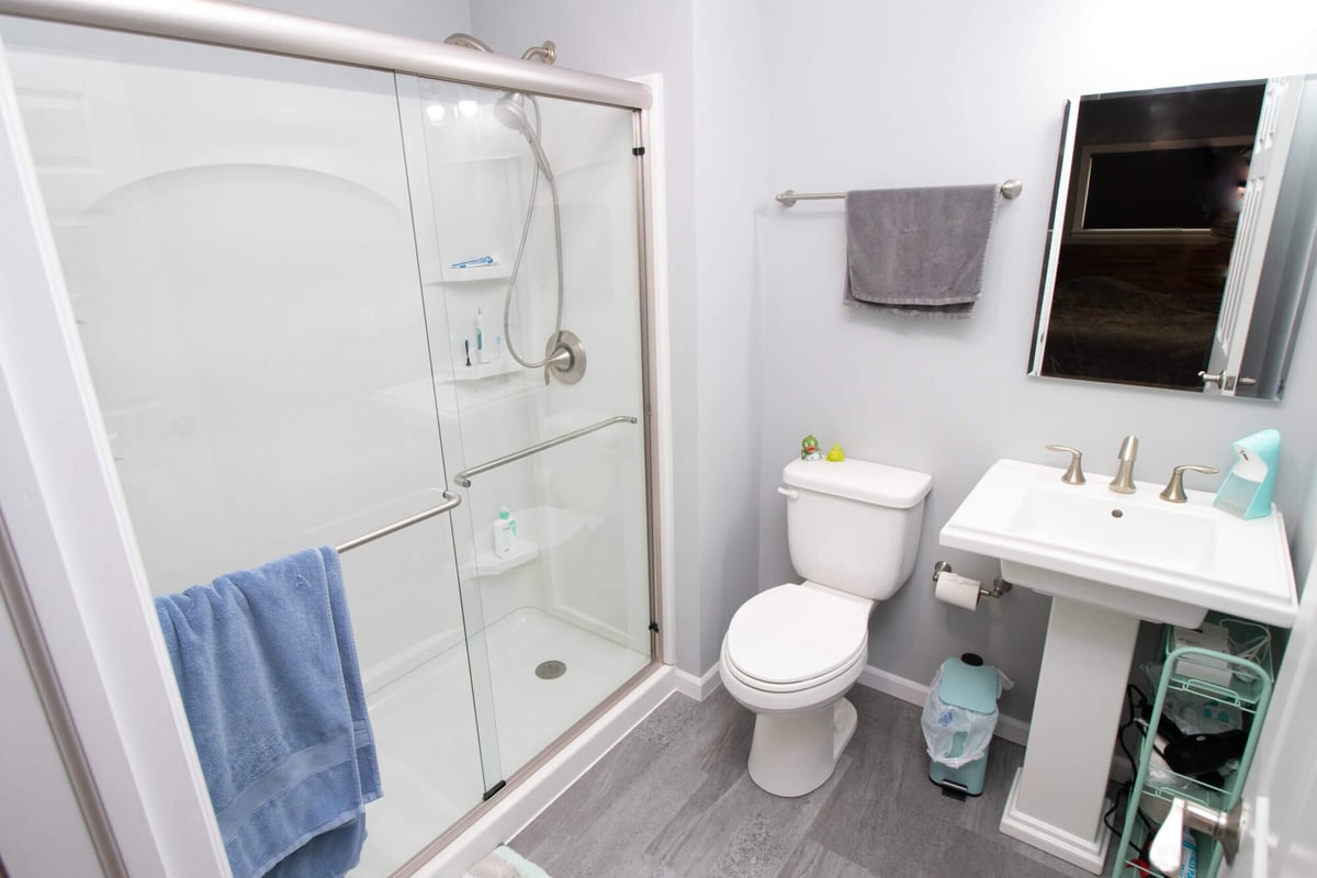 Newly completed bathroom addition with shower, toilet, and modern fixtures by Odd Fellows Contracting in Haslett, MI)