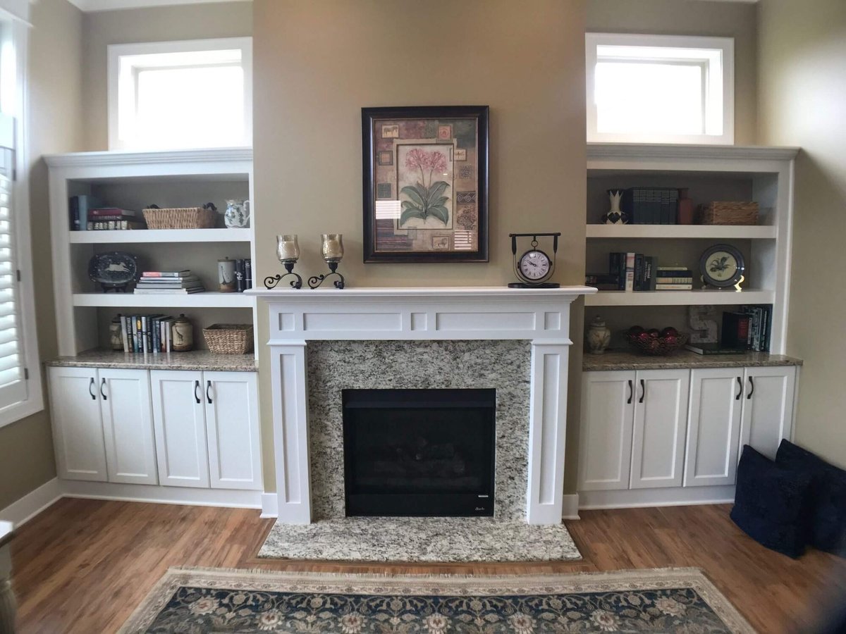 fireplace wall with custom built ins and granite hearth by Odd Fellows Contracting in Holt, MI