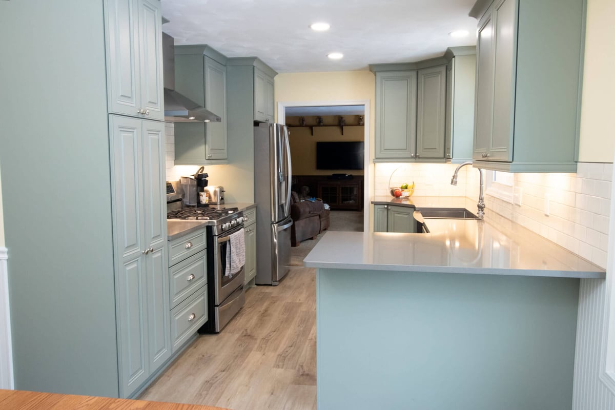kitchen renovation featuring modern cabinets, island workspace, and tile backsplash by Odd Fellows Contracting in Williamston, MI