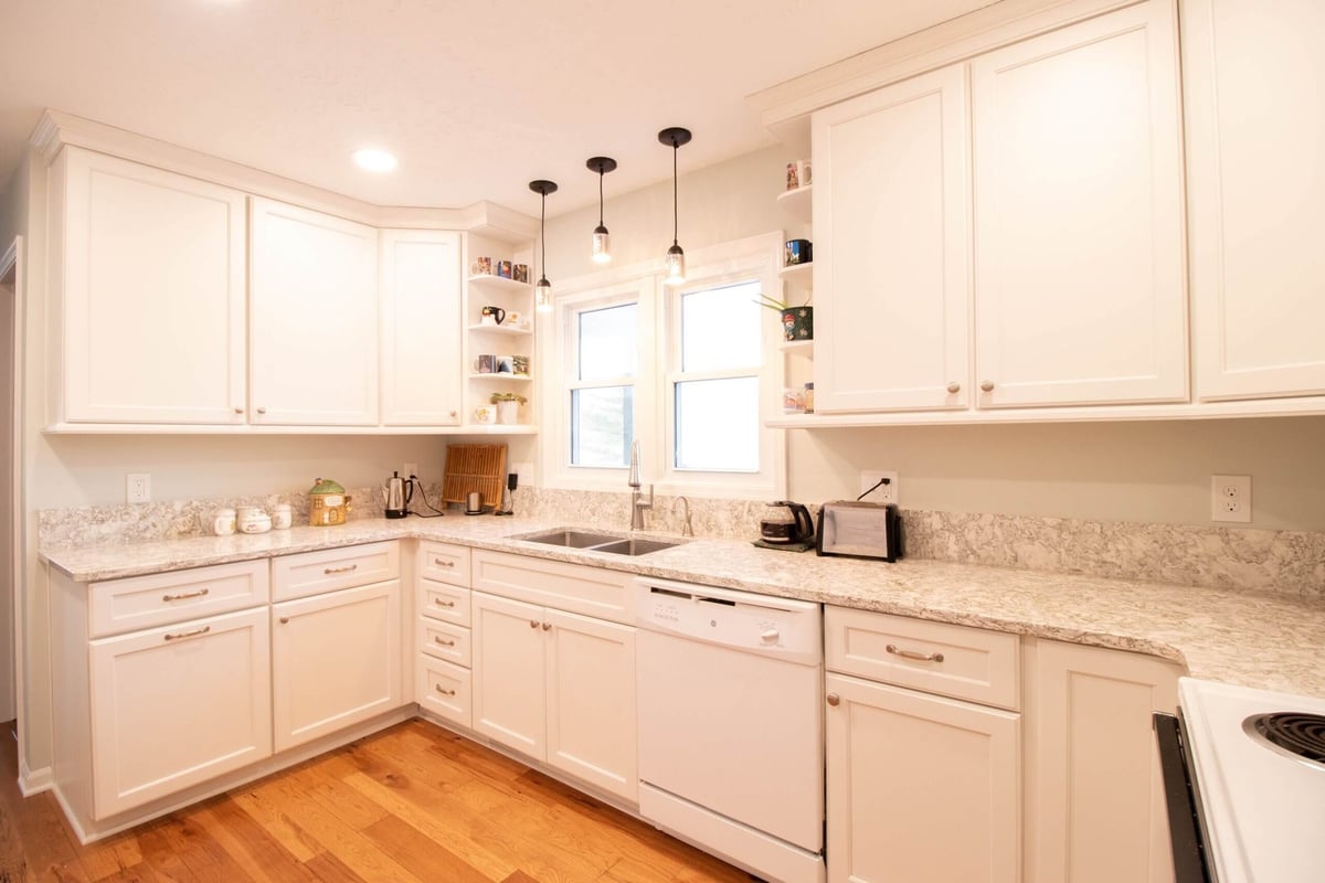 remodeled kitchen with white cabinets and double sink under window by Odd Fellows Contracting in Onondaga, MI
