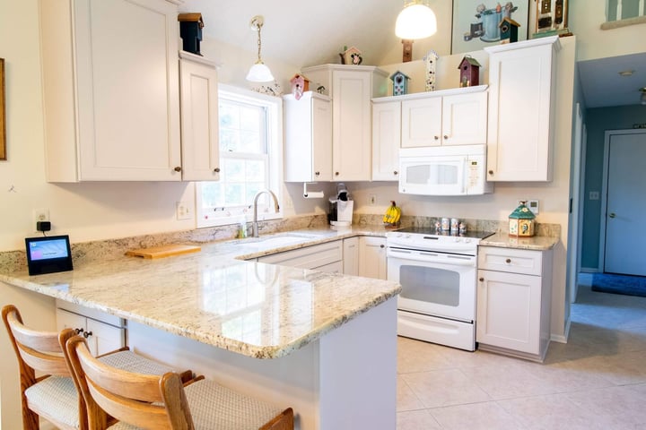 updated kitchen from remodel by Odd Fellows Contracting in Williamston, MI with granite island and pendant lighting