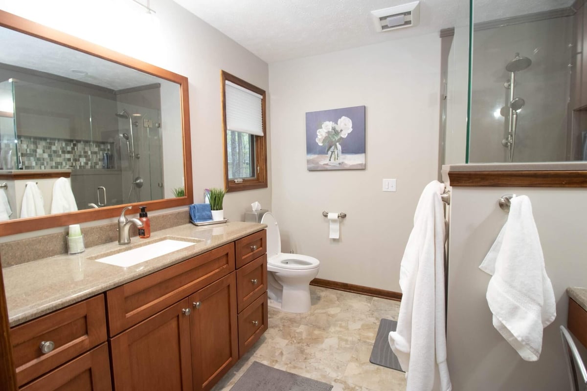 upgraded vanity, flooring, and shower in bathroom remodel by Odd Fellows Contracting in Okemos, MI