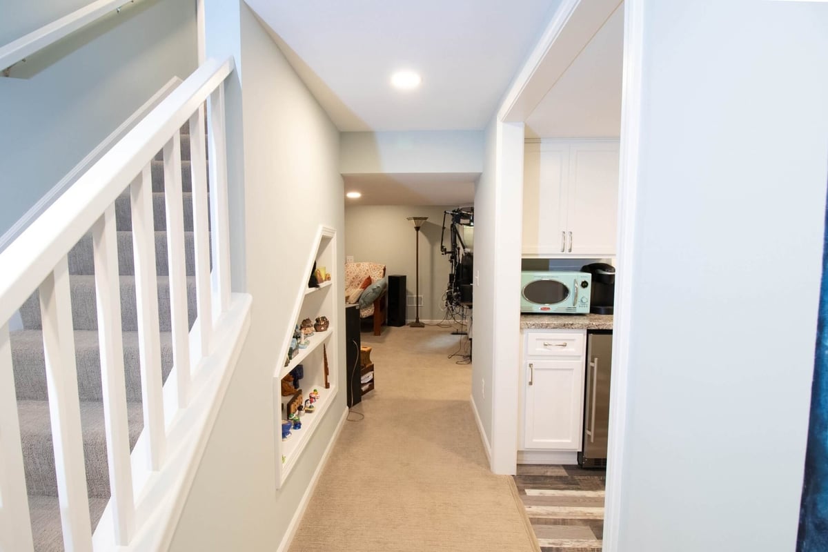 Basement hallway leading to finished living space and kitchenette area by Odd Fellows Contracting in Lansing, MI.