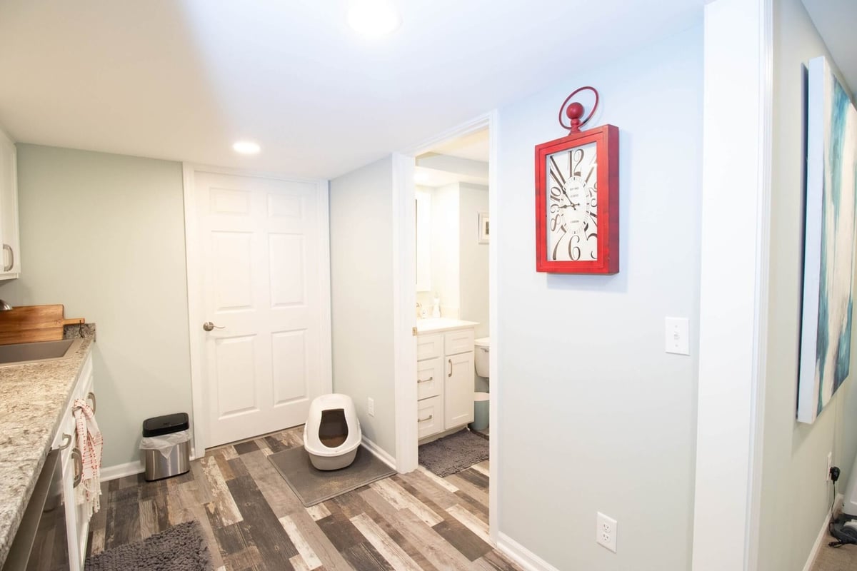Finished basement with kitchenette, storage cabinets, and modern flooring by Odd Fellows Contracting in Lansing, MI.