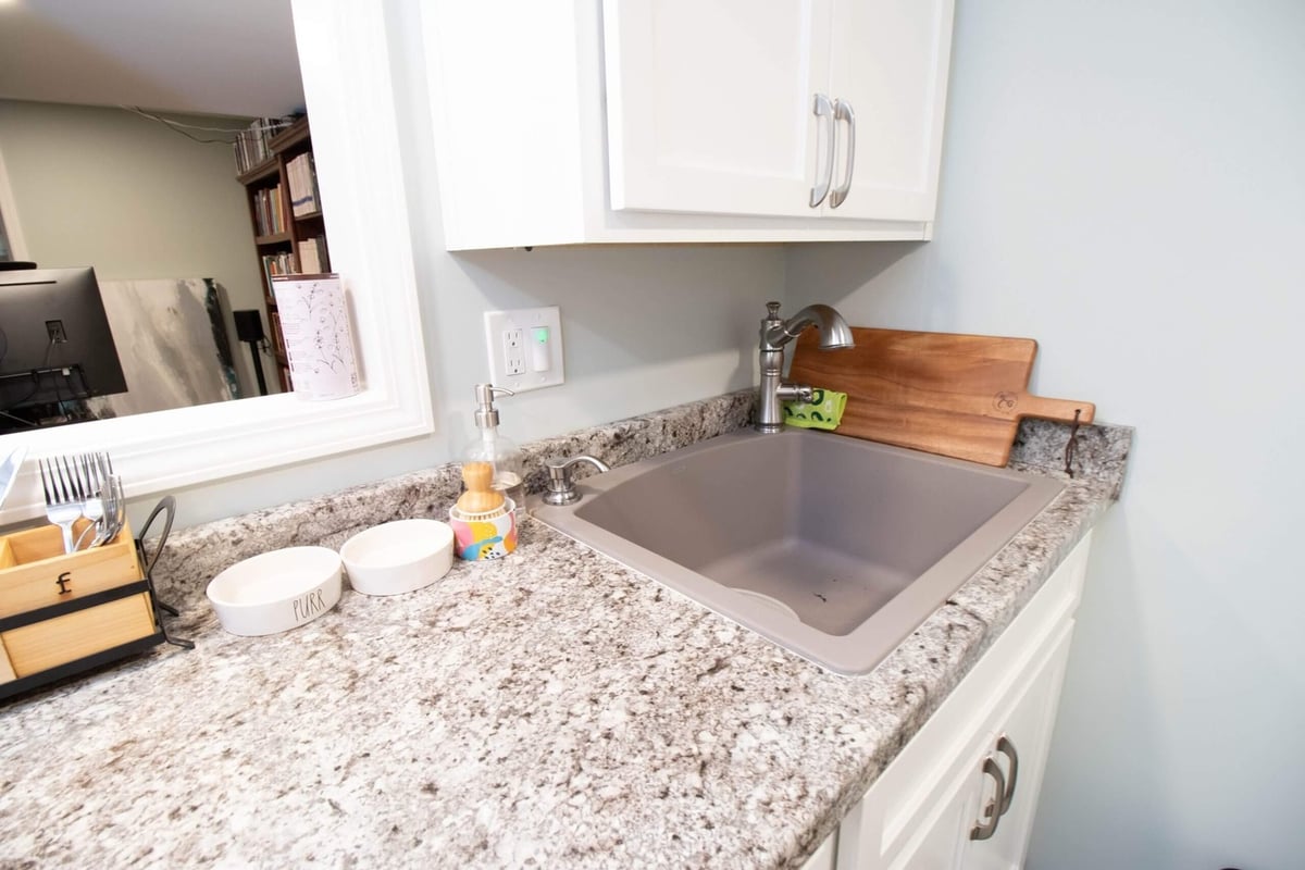basement remodel kitchenette sink with granite countertop and white cabinetry by Odd Fellows Contracting in Lansing, MI