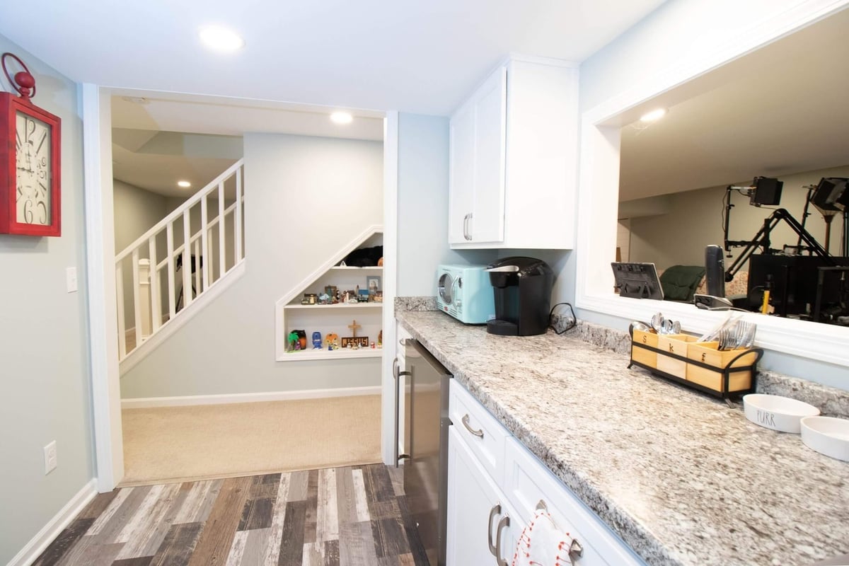 basement renovation featuring granite countertop bar area and built-in storage by Odd Fellows Contracting in Lansing, MI