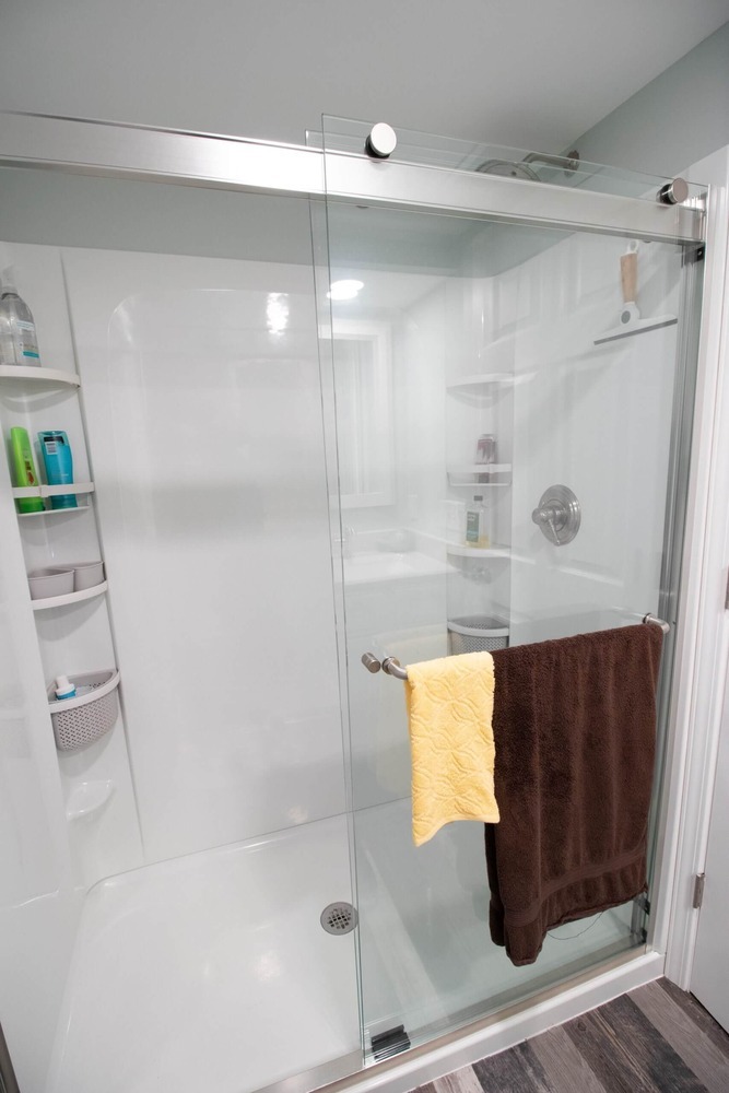 glass sliding shower door installed during basement bathroom remodel by Odd Fellows Contracting in Lansing, MI
