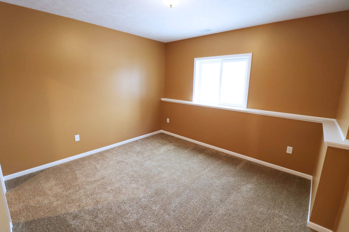 basement bedroom addition with painted walls and carpet by Odd Fellows Contracting Williamston MI