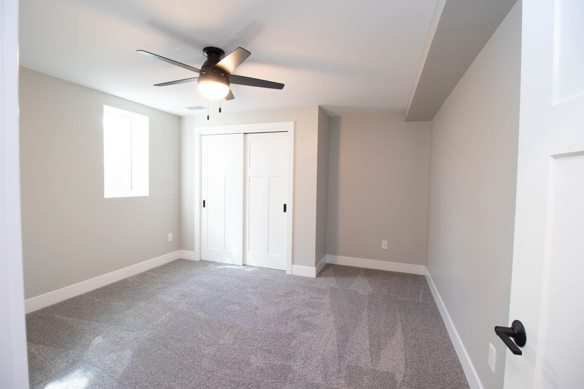 basement bedroom remodel by Odd Fellows Contracting in Mason MI featuring closet and neutral finishes