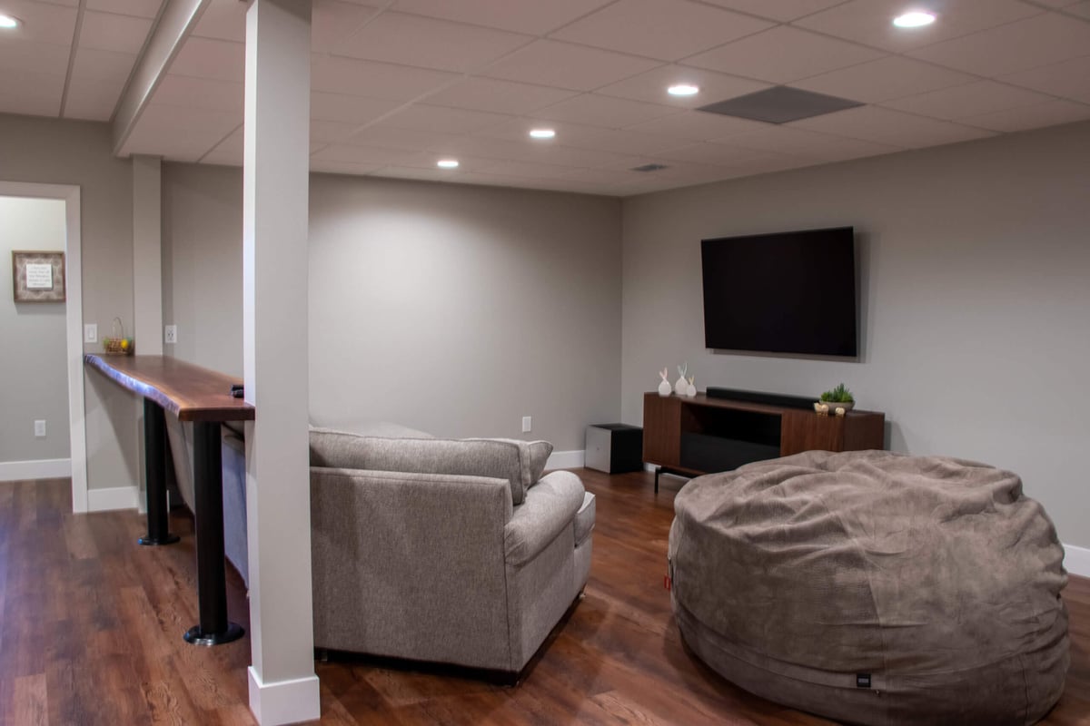 finished basement by Odd Fellows Contracting in Mason MI with sectional seating and wall mounted TV