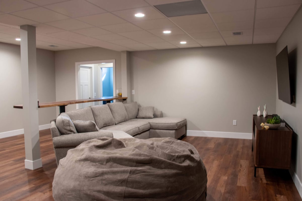 updated basement living area by Odd Fellows Contracting in Mason MI with wood floors and modern decor