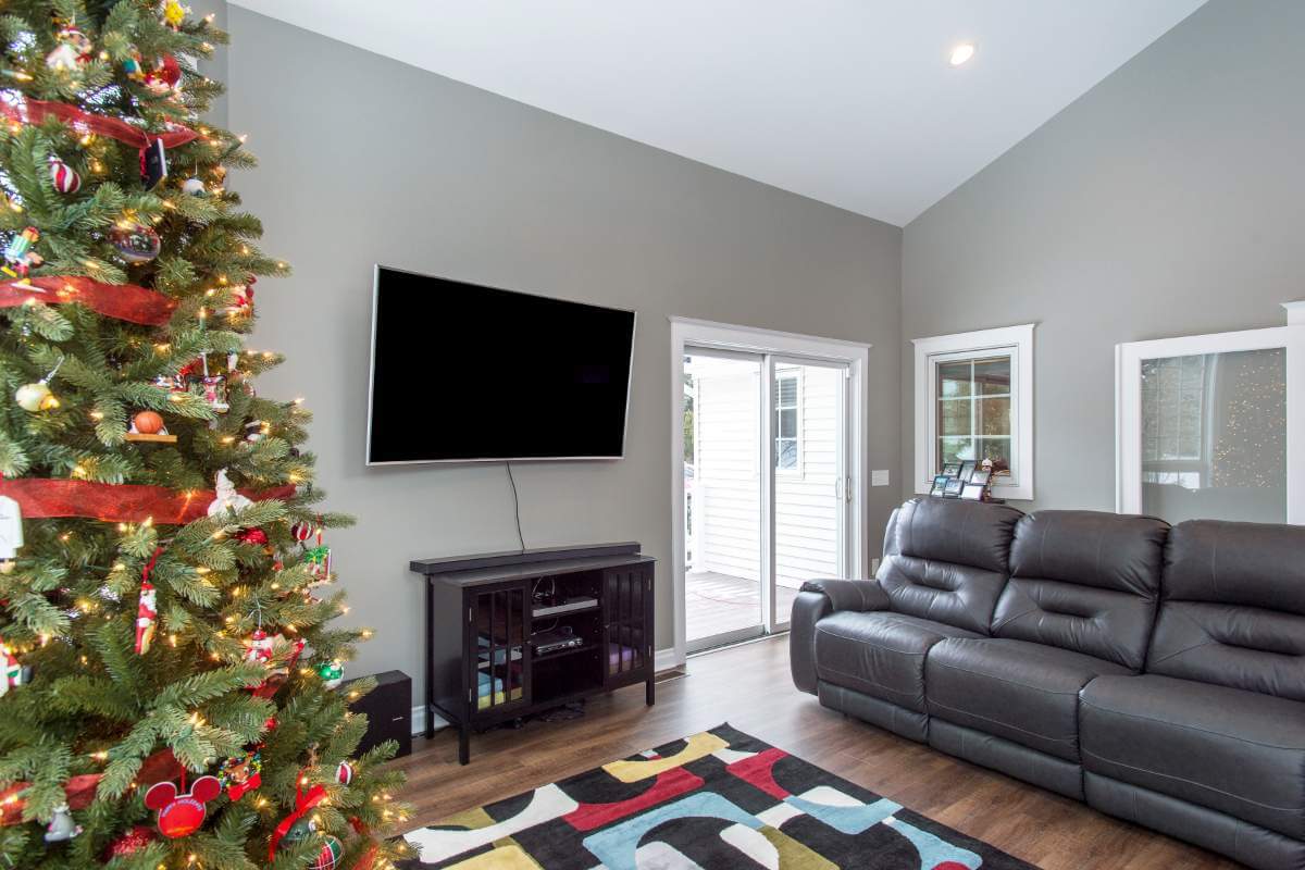 family room addition with wall mounted TV and sliding glass door by Odd Fellows Contracting in Okemos, MI