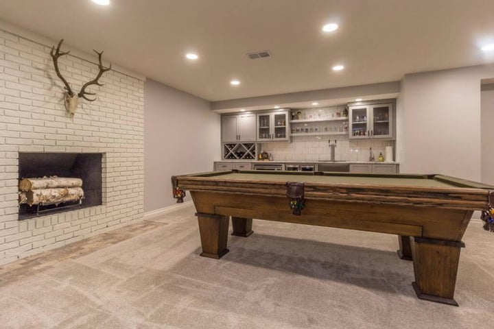 Finished basement game room in East Lansing MI with pool table, white brick fireplace, and custom bar by Odd Fellows Contracting Finished basement game room in East Lansing MI with pool table, white brick fireplace, and custom bar by Odd Fellows Contracting