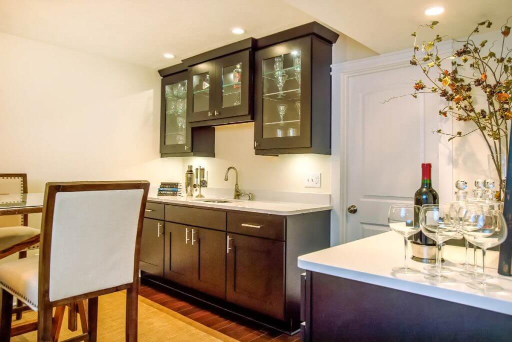 Custom basement wet bar with dark cabinets built by Odd Fellows Contracting in Lansing Michigan