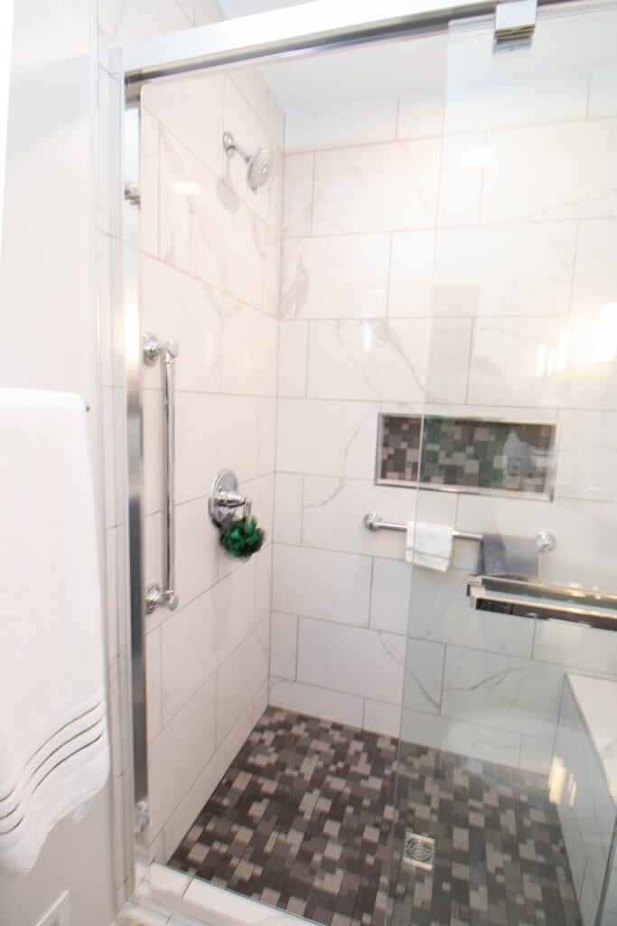 walk-in tile shower with glass door installed during bathroom remodel by Odd Fellows Contracting in East Lansing, MI