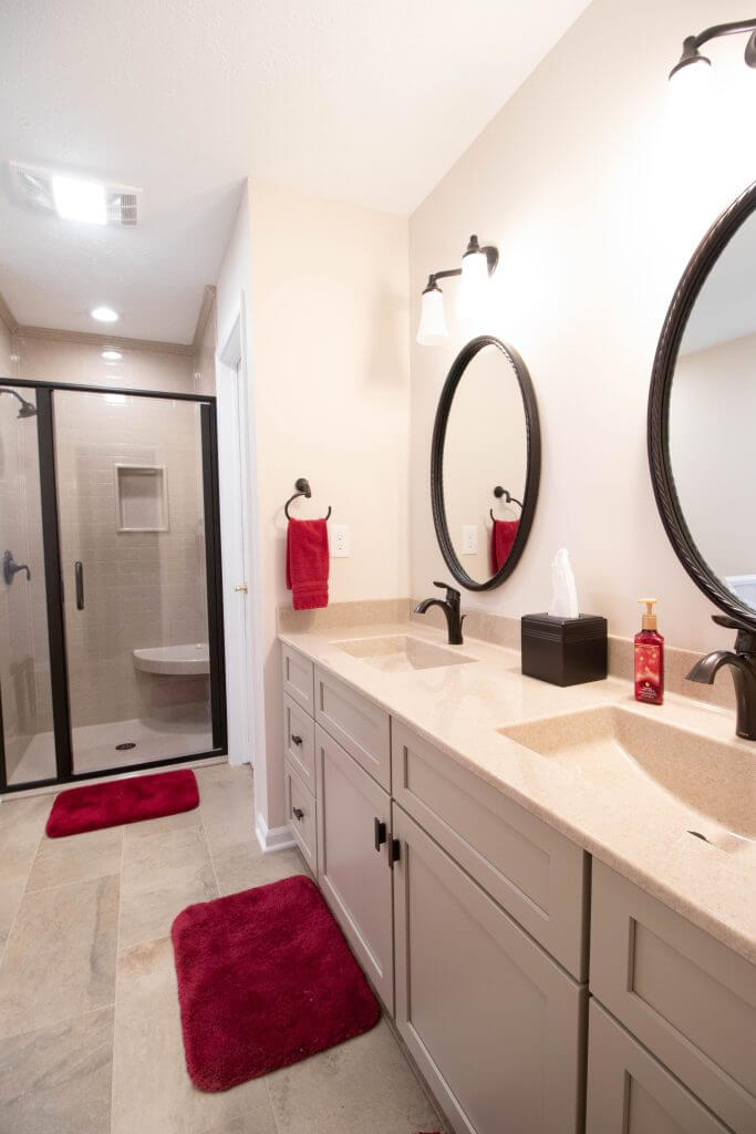 bathroom remodel featuring double vanity with round mirrors by Odd Fellows Contracting in Lansing, MI