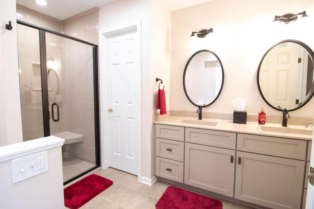 bright bathroom remodel with dual sink vanity and tiled shower by Odd Fellows Contracting in Lansing, MI