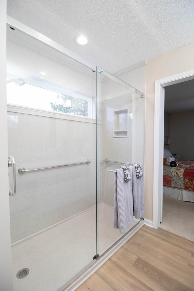 glass walk-in shower with grab bars from bathroom remodel by Odd Fellows Contracting in Dewitt, MI