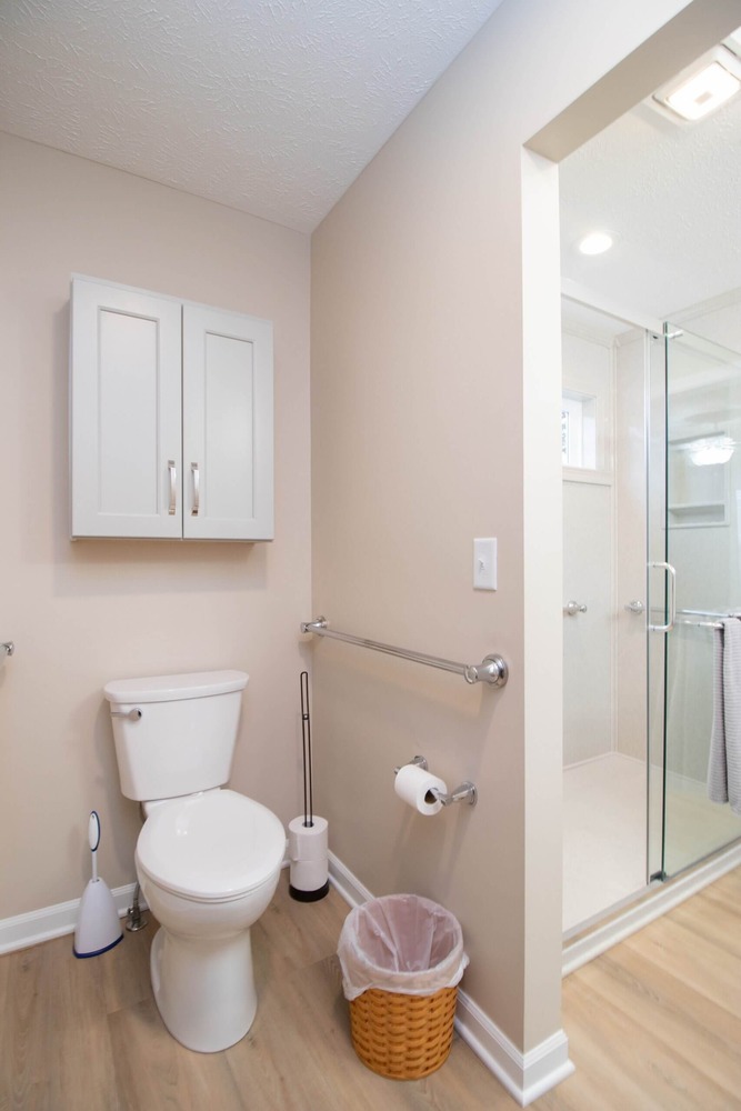 remodeled bathroom toilet area with wall cabinet storage by Odd Fellows Contracting in Dewitt, MI