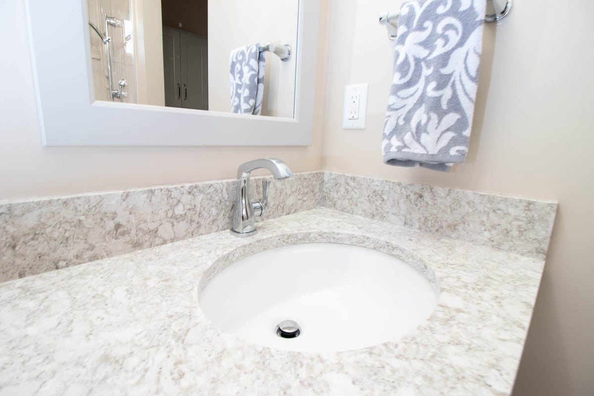 remodeled bathroom vanity with stone countertop and modern faucet by Odd Fellows Contracting in Dewitt, MI