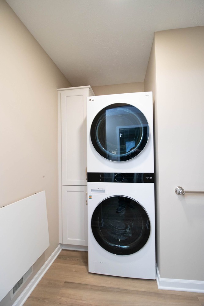 stacked LG washer and dryer installed in remodeled bathroom by Odd Fellows Contracting in Dewitt, MI