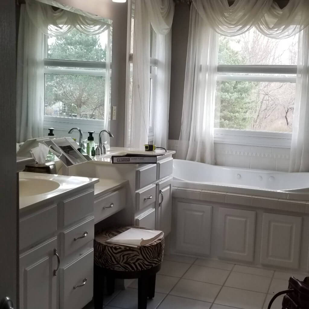Bathroom before remodel with outdated vanity and corner bathtub prior to renovation by Odd Fellows Contracting in DeWitt, MI.