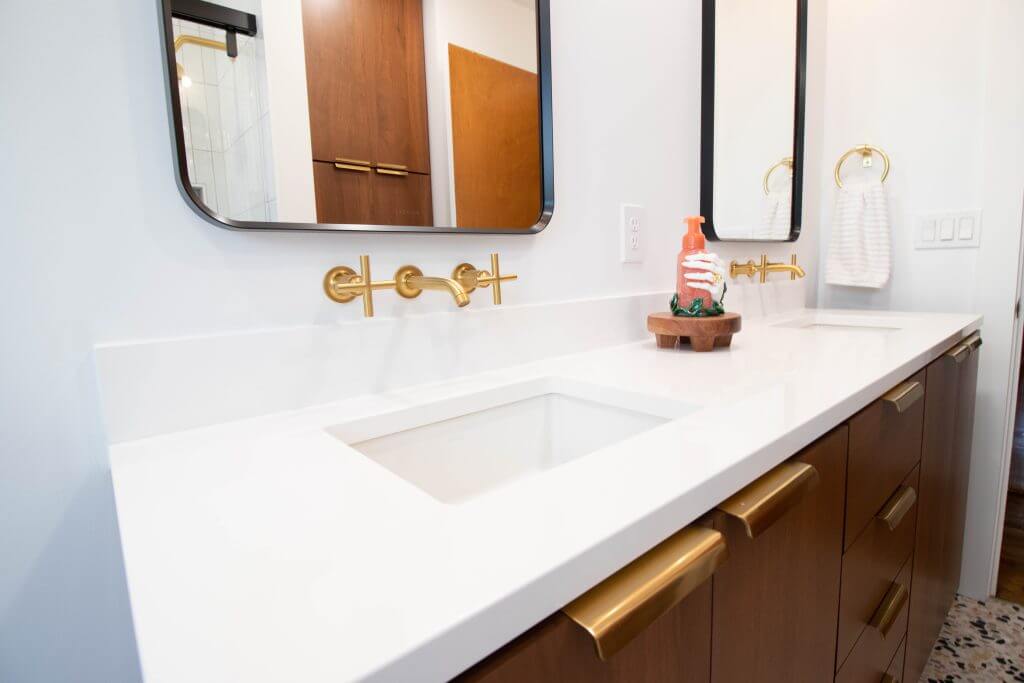 bathroom remodel vanity detail with wall-mounted faucet and quartz sink by Odd Fellows Contracting in Lansing, MI
