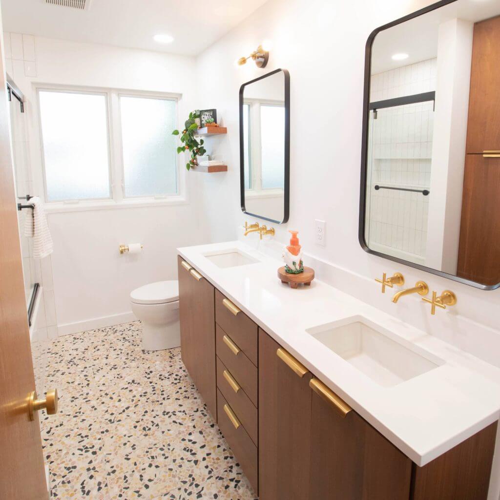 finished bathroom remodel with double vanity, terrazzo flooring, and modern gold fixtures by Odd Fellows Contracting in Lansing, MI