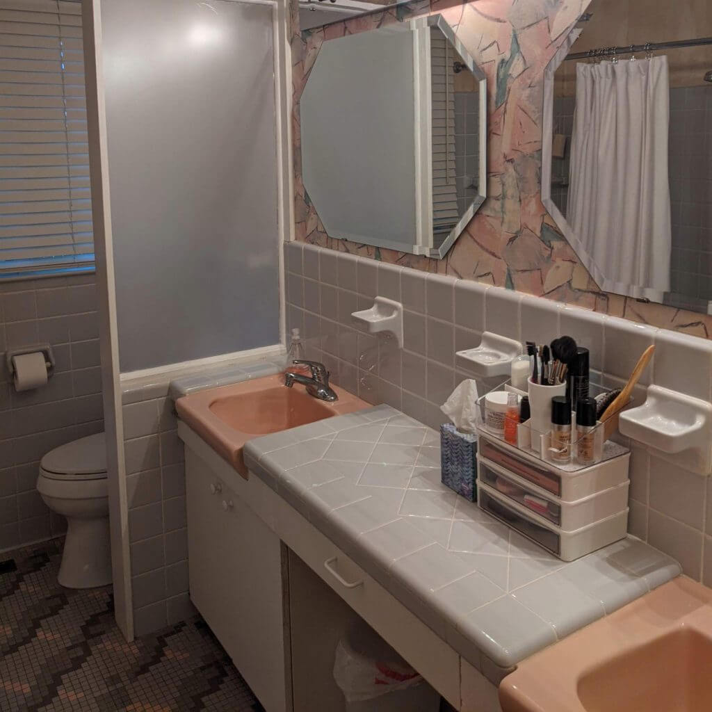 outdated bathroom before remodel with pink sink, tiled countertop, and frosted shower door in Lansing, MI by Odd Fellows Contracting