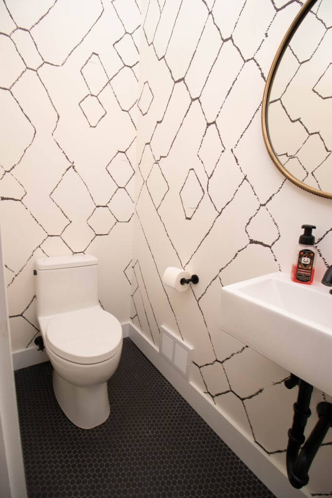 remodeled powder room with modern toilet and wall-mounted sink by Odd Fellows Contracting in Lansing, MI