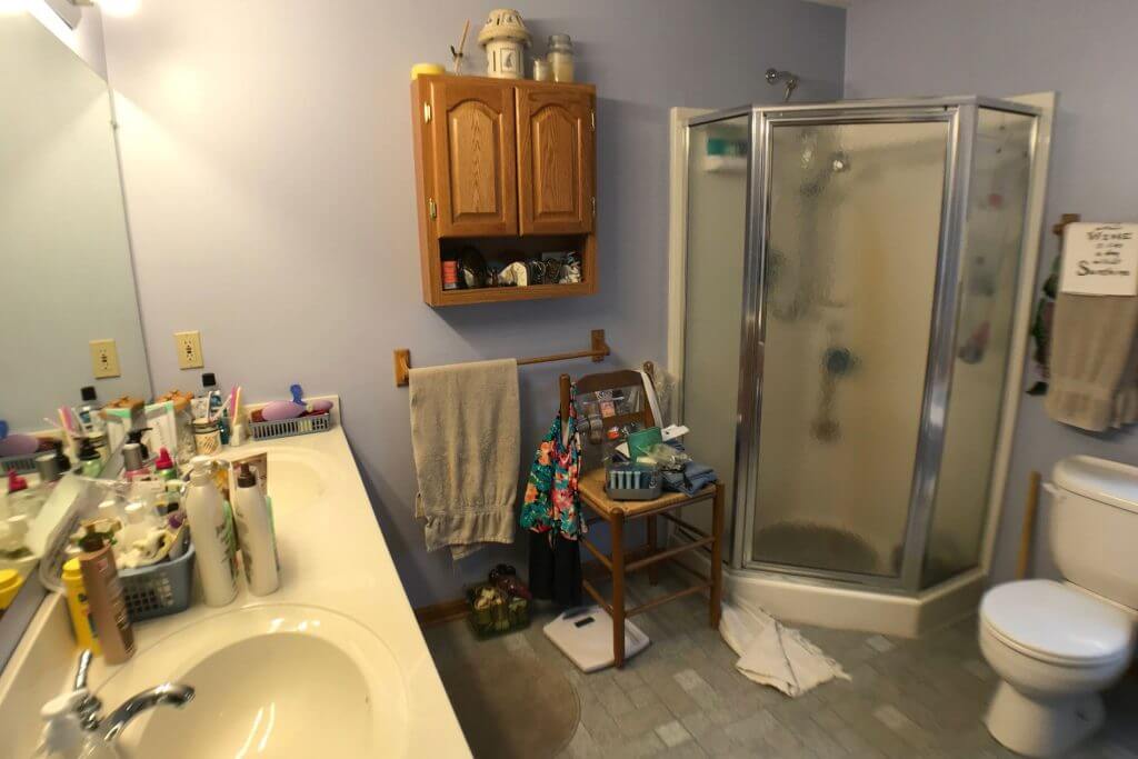 outdated bathroom before remodel with corner shower and single vanity in Laingsburg, MI by Odd Fellows Contracting