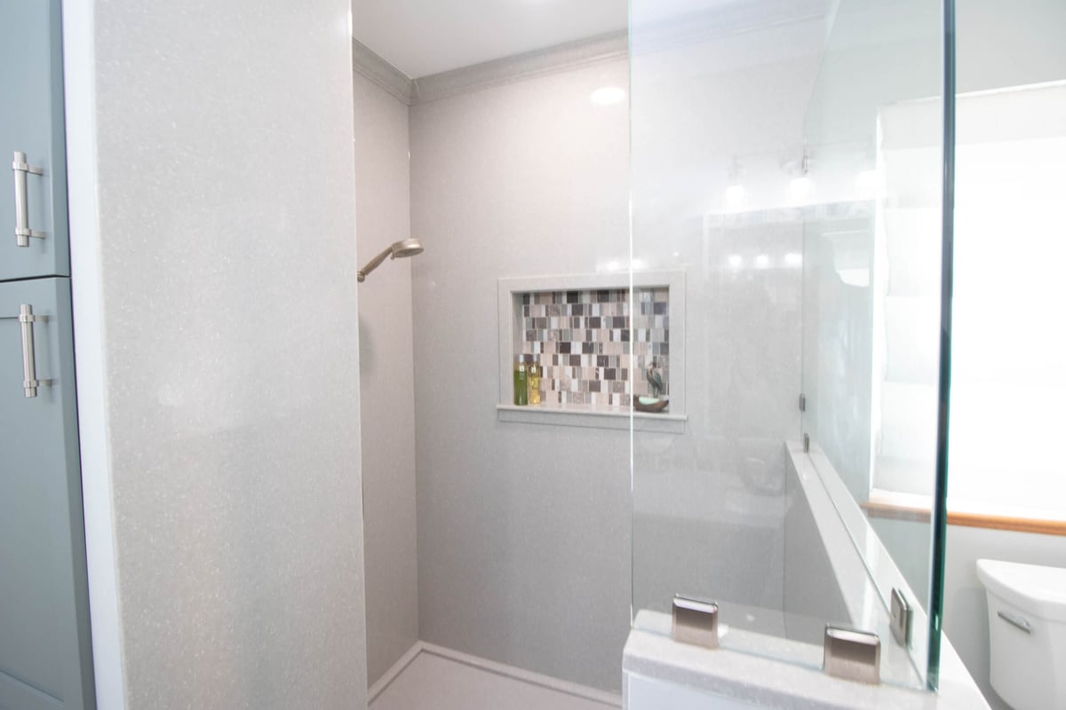 updated bathroom with half wall shower enclosure by Odd Fellows Contracting in Laingsburg, MI