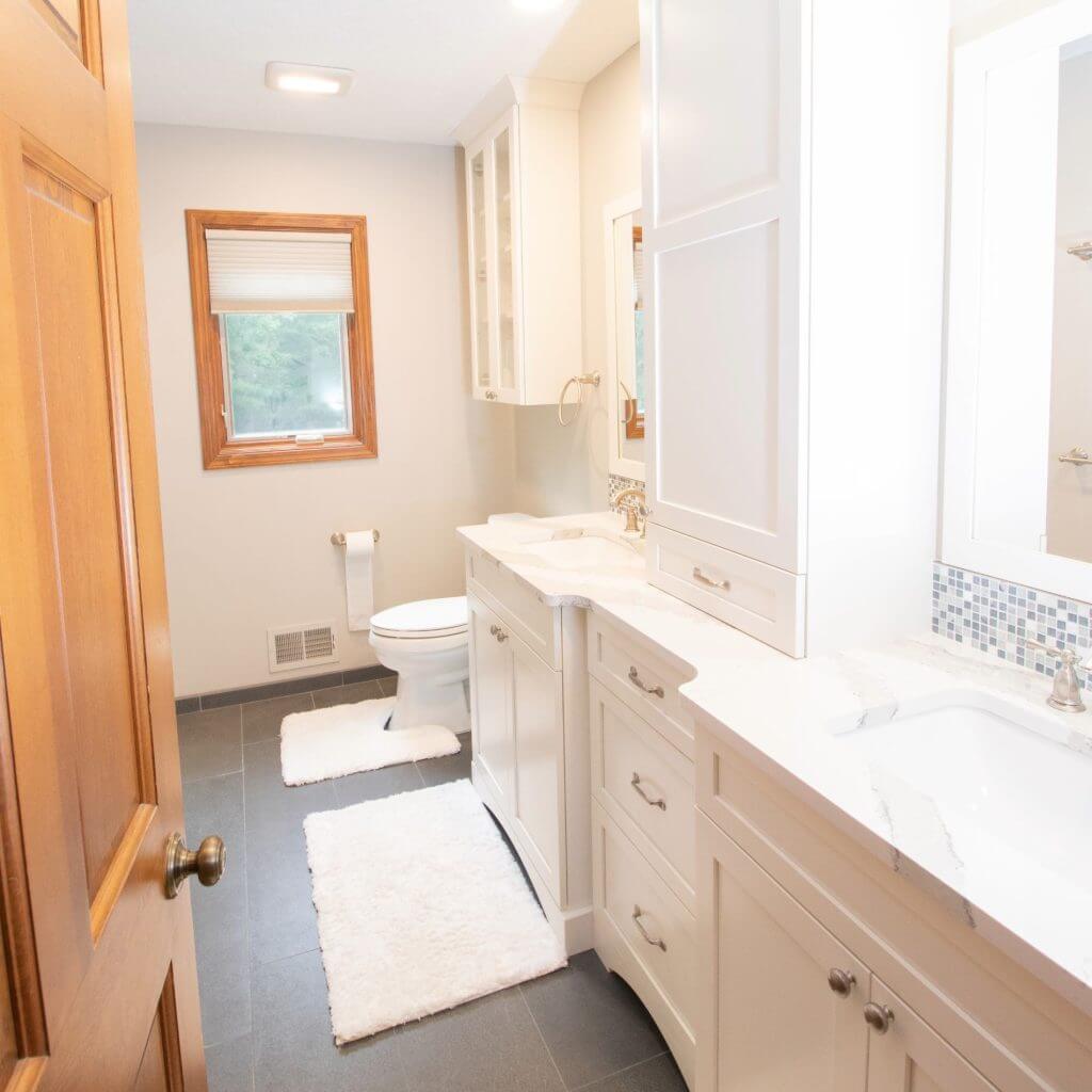 Completed bathroom remodel with white vanity and quartz countertop by Odd Fellows Contracting in Okemos, MI