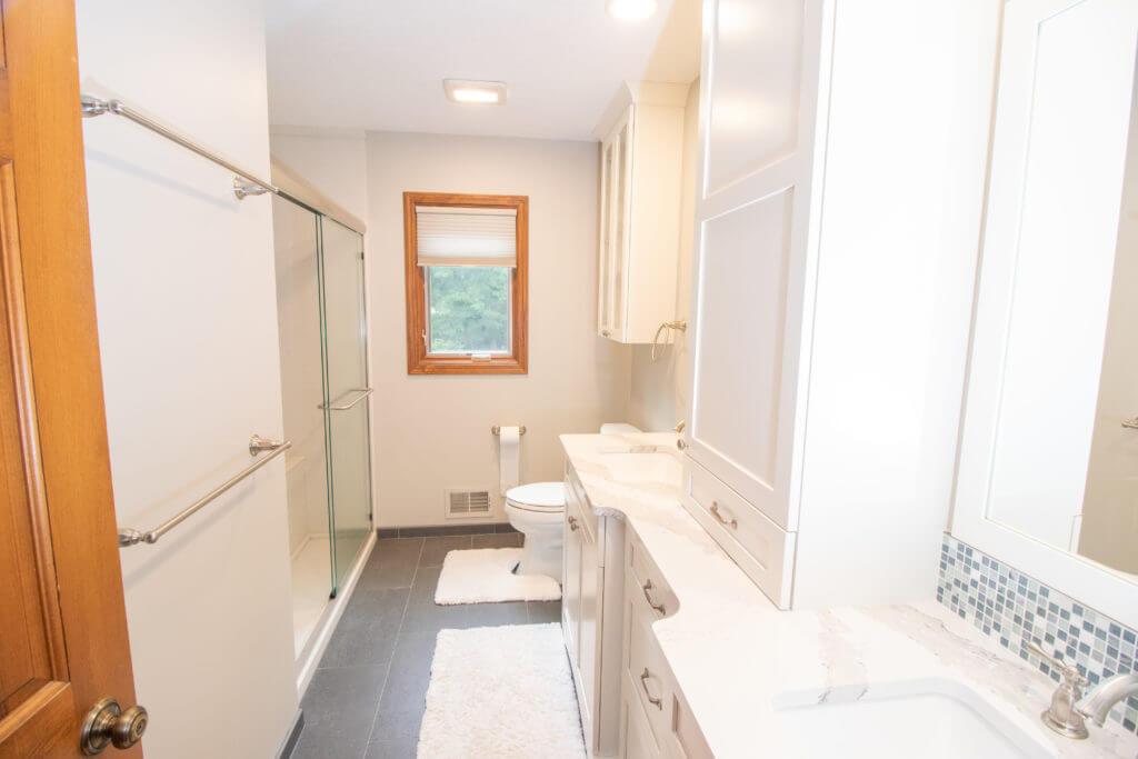 Newly renovated bathroom with glass shower enclosure by Odd Fellows Contracting in Okemos, MI