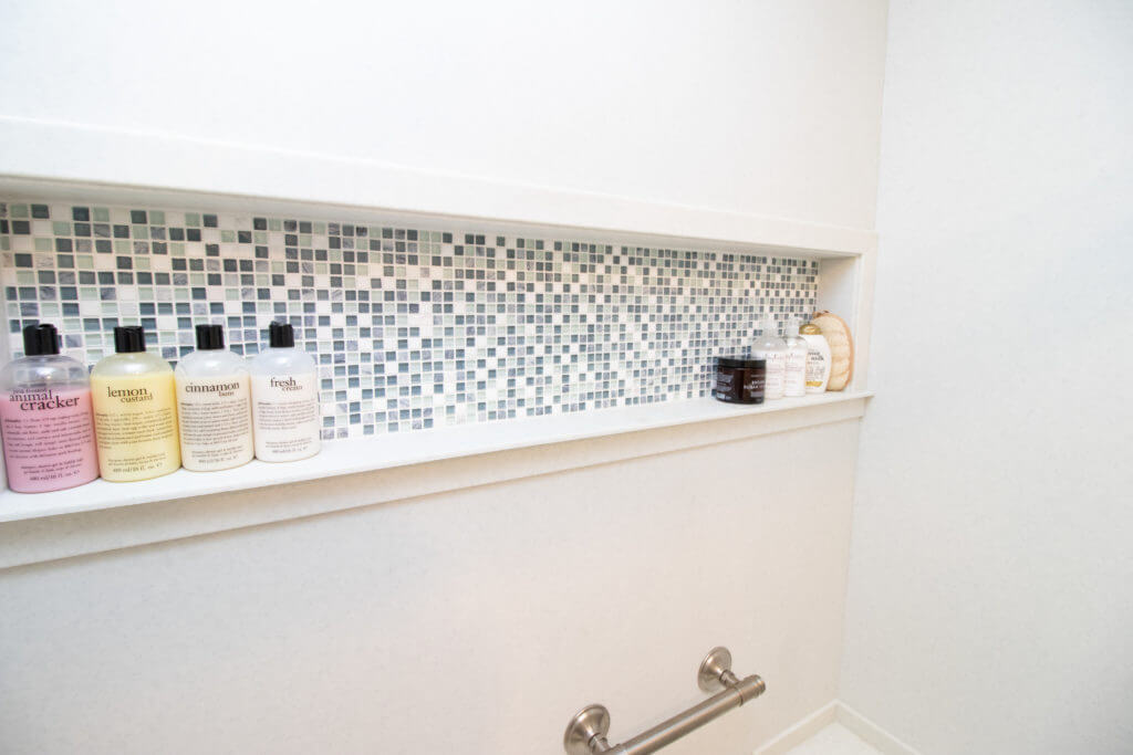 Shower niche with mosaic tile accent from bathroom remodel by Odd Fellows Contracting in Okemos, MI