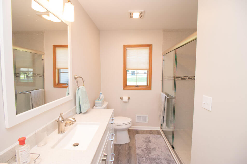 Bathroom remodel with modern vanity and walk-in shower by Odd Fellows Contracting in Williamston, MI