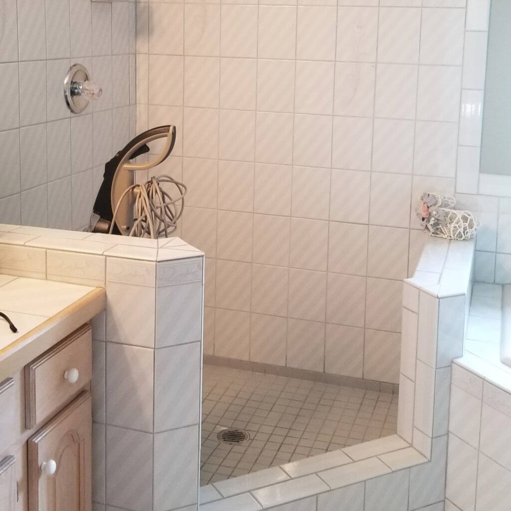 Before bathroom remodeled into modern walk-in shower and vanity by Odd Fellows Contracting in Williamston, MI