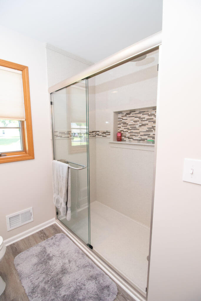 Modern bathroom shower remodel with glass enclosure by Odd Fellows Contracting in Williamston, MI