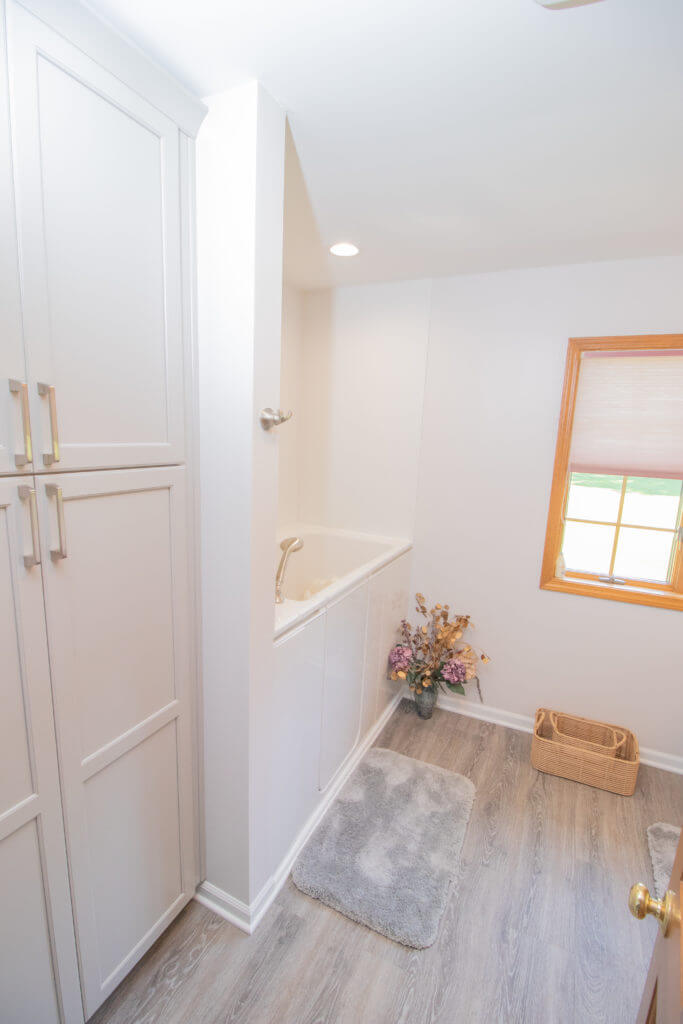 Renovated bathroom with tub surround and custom cabinetry by Odd Fellows Contracting in Williamston, MI