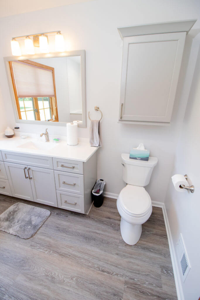 Updated bathroom vanity with modern fixtures and cabinetry by Odd Fellows Contracting in Williamston, MI