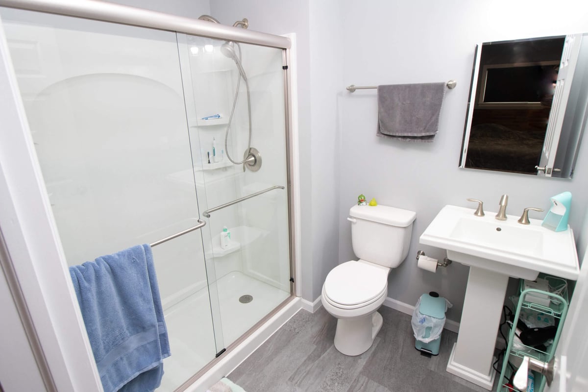 Newly completed bathroom addition with shower, toilet, and modern fixtures by Odd Fellows Contracting in Haslett, MI)