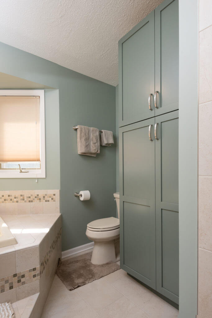 bathroom remodel with green vanity cabinet and hardwood flooring by Odd Fellows Contracting Mason MI