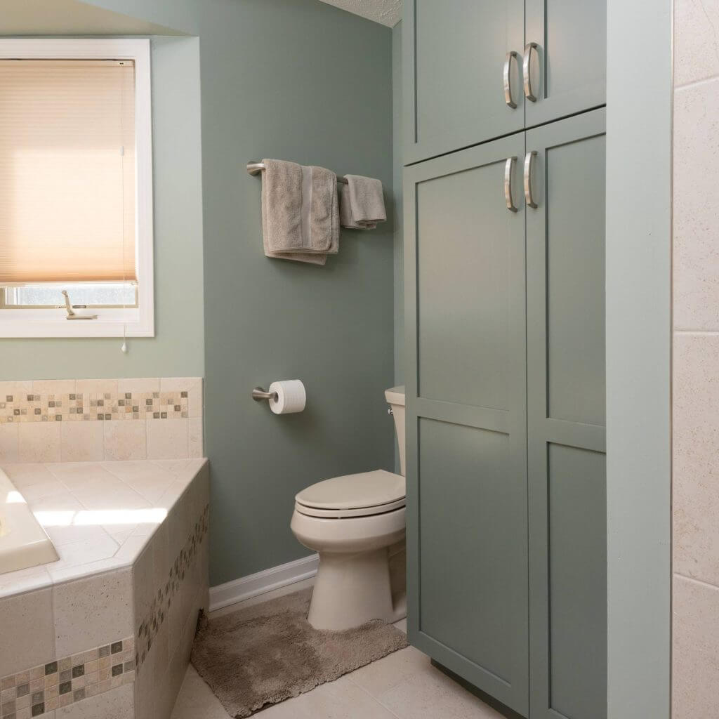 remodeled bathroom with green vanity cabinets and bathtub by Odd Fellows Contracting in Mason MI