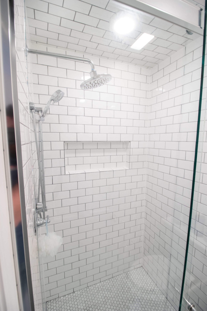tiled walk-in shower with subway tile and glass enclosure by Odd Fellows Contracting in Okemos MI