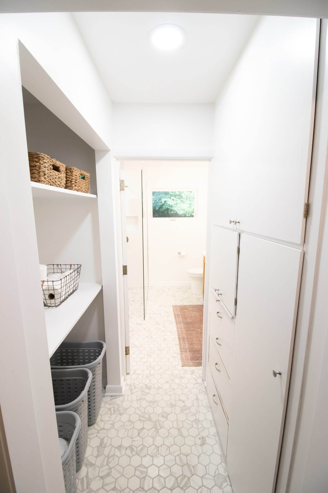 Built-in bathroom storage and laundry area added during remodel by Odd Fellows Contracting in Lansing MI