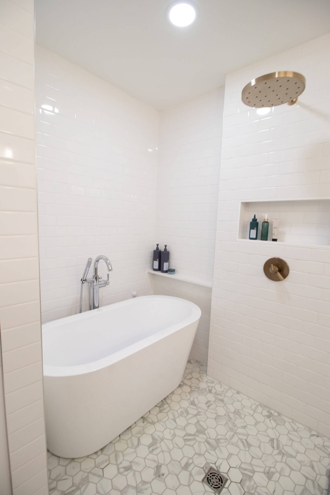 White subway tile shower with rainfall fixture and soaking tub by Odd Fellows Contracting