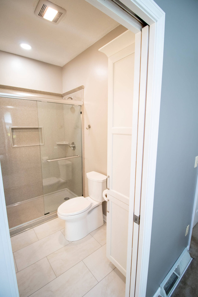 bathroom remodel featuring glass shower enclosure, tile flooring, and updated fixtures by Odd Fellows Contracting in Williamston, MI