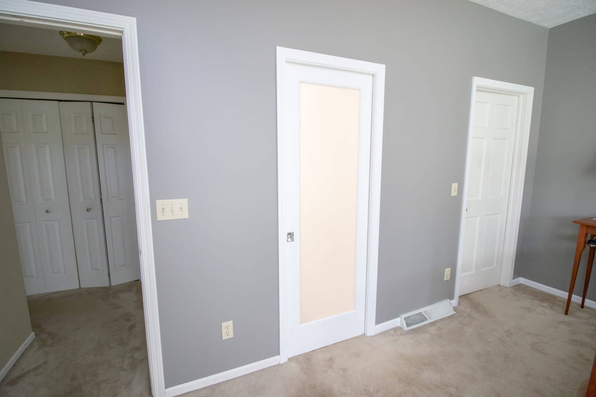 bedroom view featuring modern sliding barn door installed during bathroom remodel by Odd Fellows Contracting in Williamston, MI