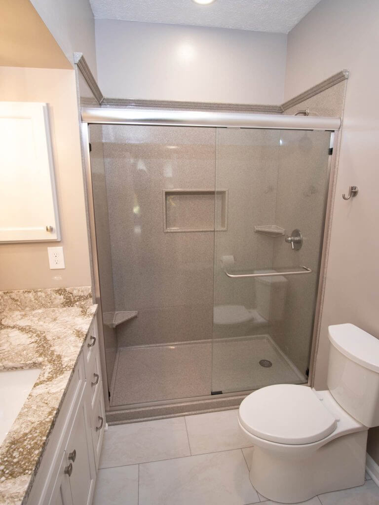 updated bathroom remodel featuring glass shower enclosure, modern vanity, and tile flooring by Odd Fellows Contracting in Williamston, MI